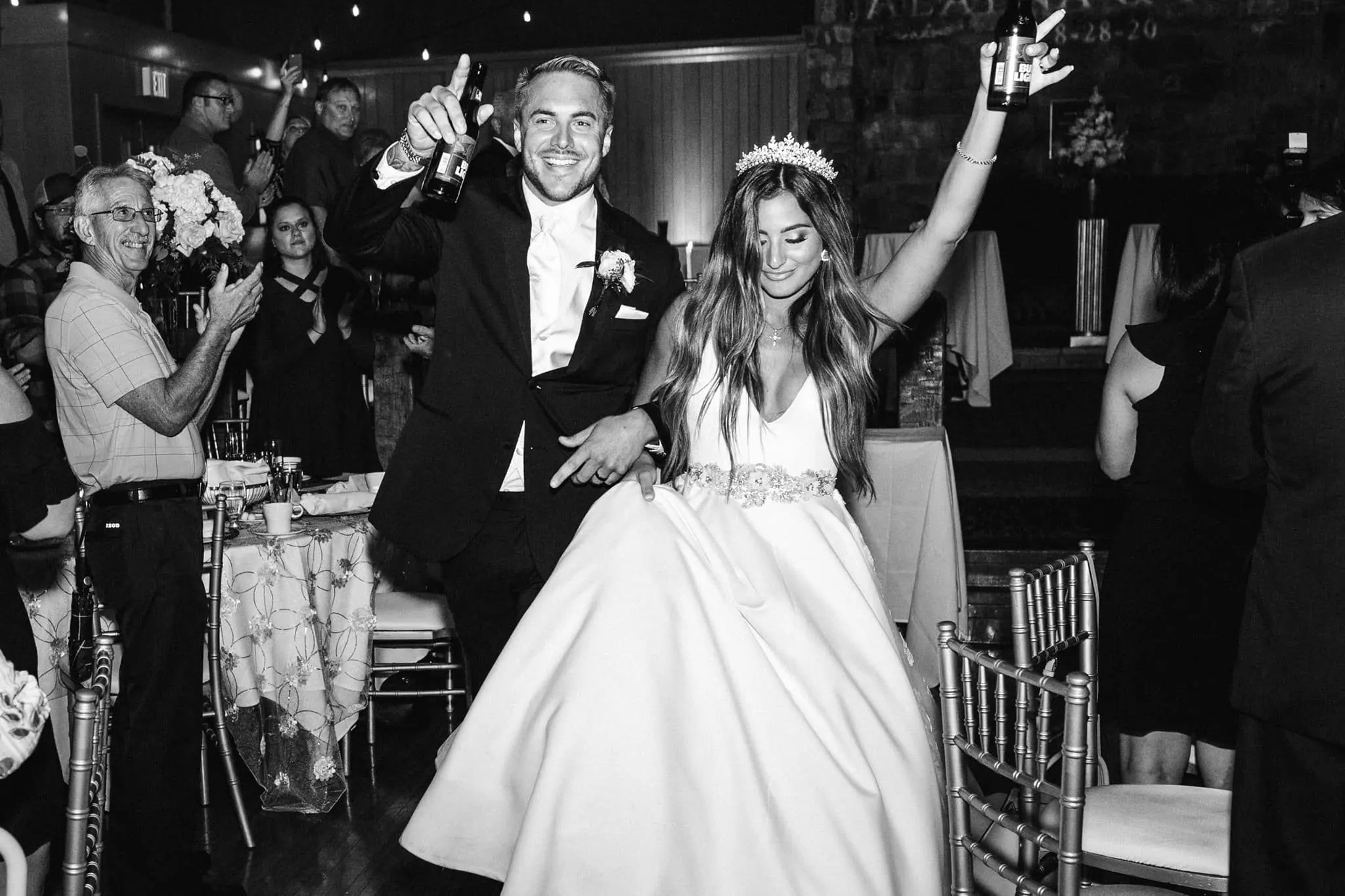Bride and groom make a joyful grand entrance into their wedding reception