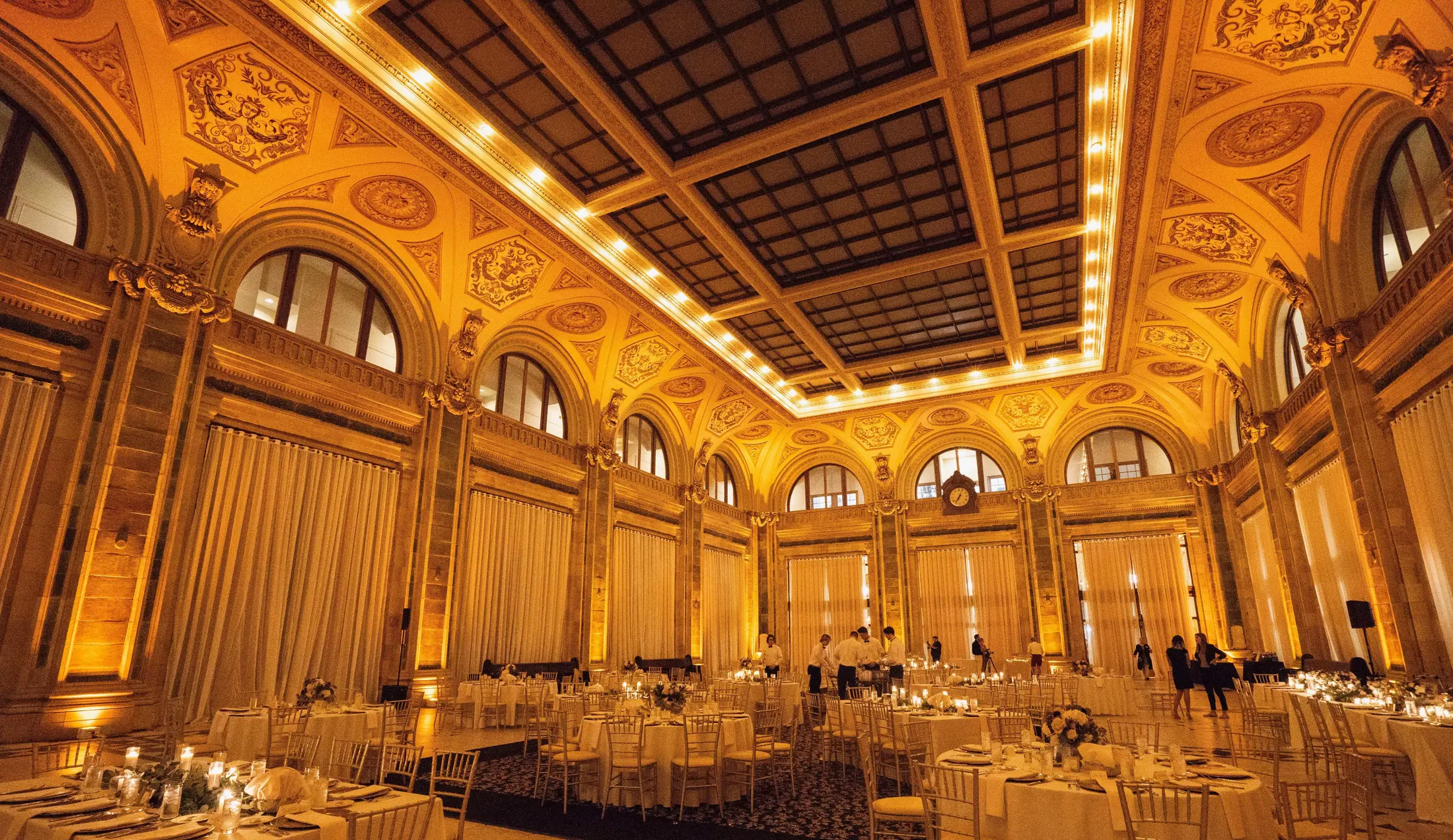 Historic Pittsburgh ballroom washed in amber uplighting for a wedding reception