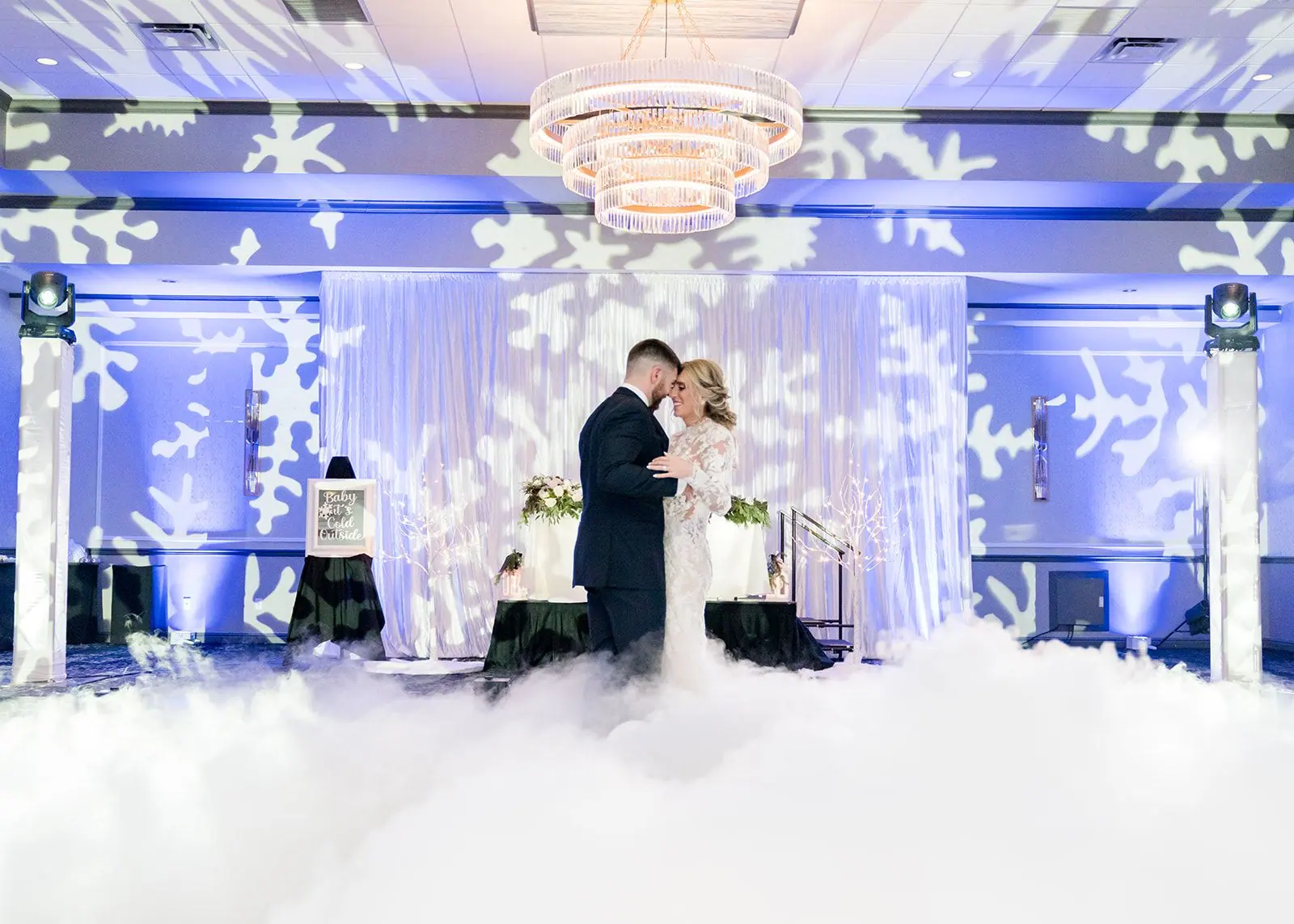 Bride and groom share a first dance in low fog under snowflake lighting in a Pittsburgh-area ballroom